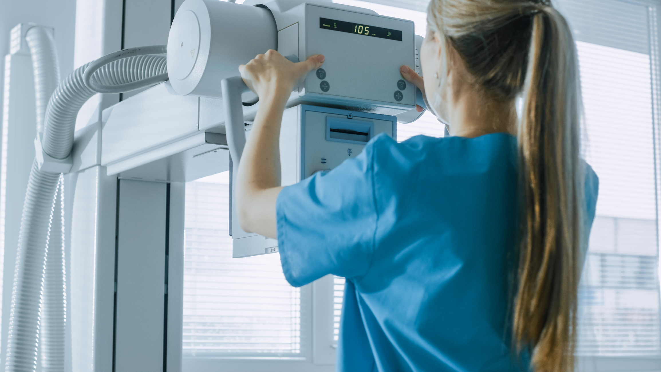 In the Hospital, Female Technician adjusts X-Ray Scanner / Machine. Modern Hospital with Technologically Advanced Medical Equipment and Professional Personnel.